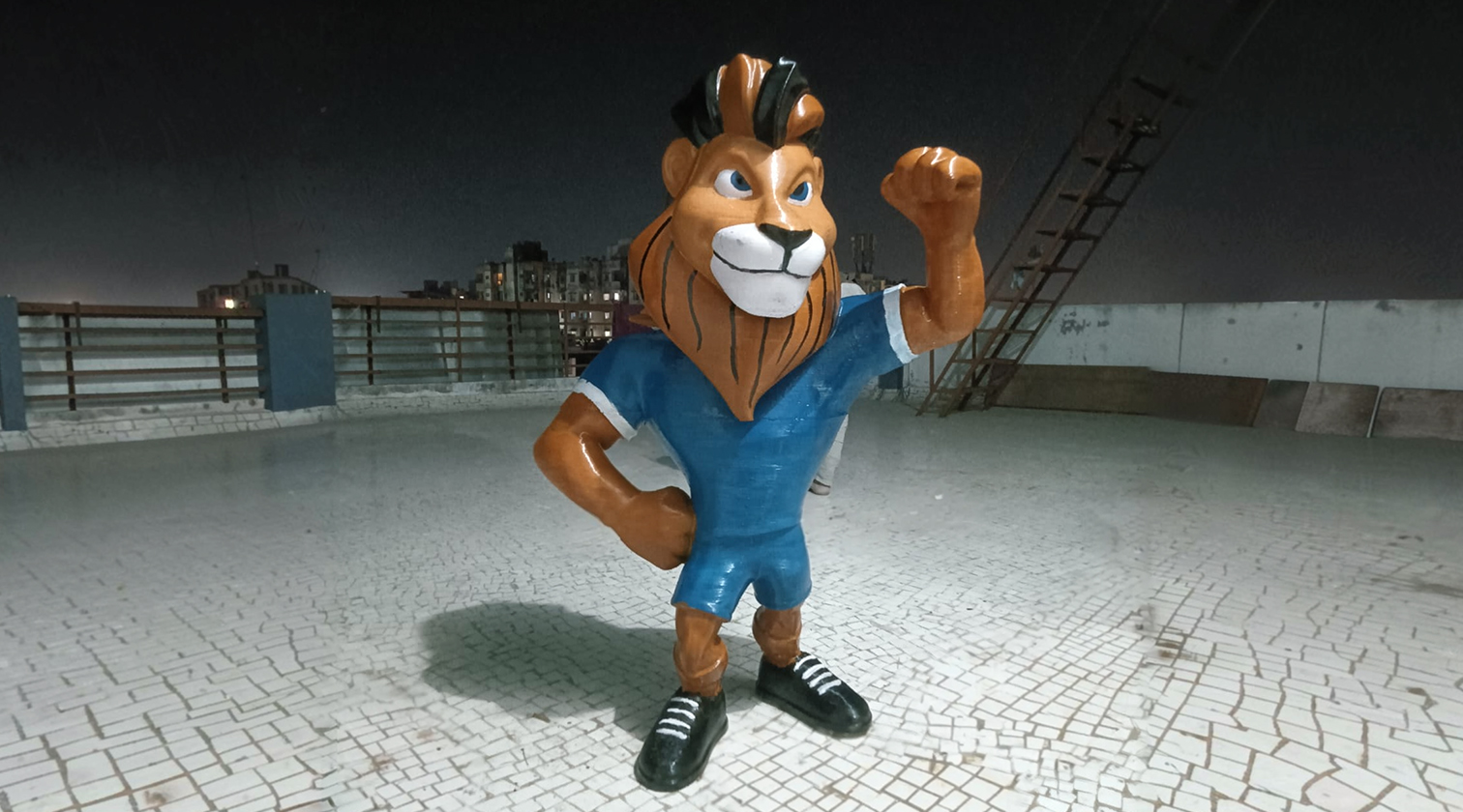 Finished painted life-size lion mascot in blue jersey on a rooftop in Gandhinagar